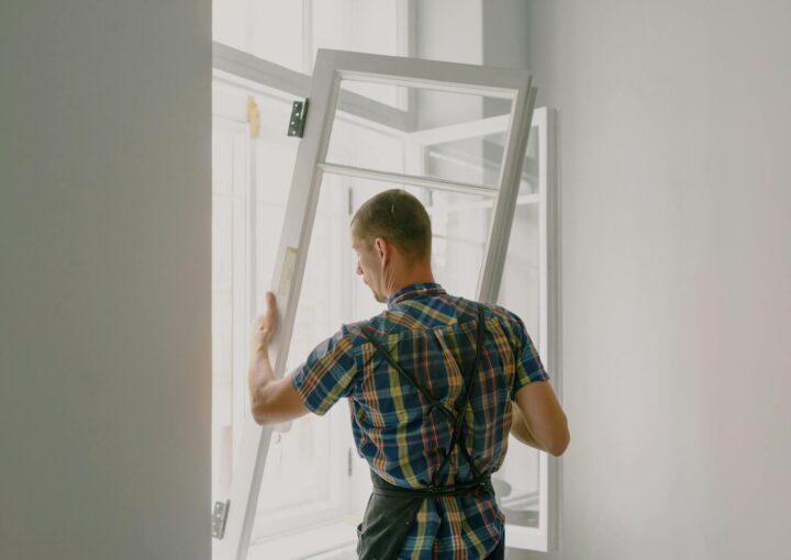 unrecognizable workman installing window in house during renovation process