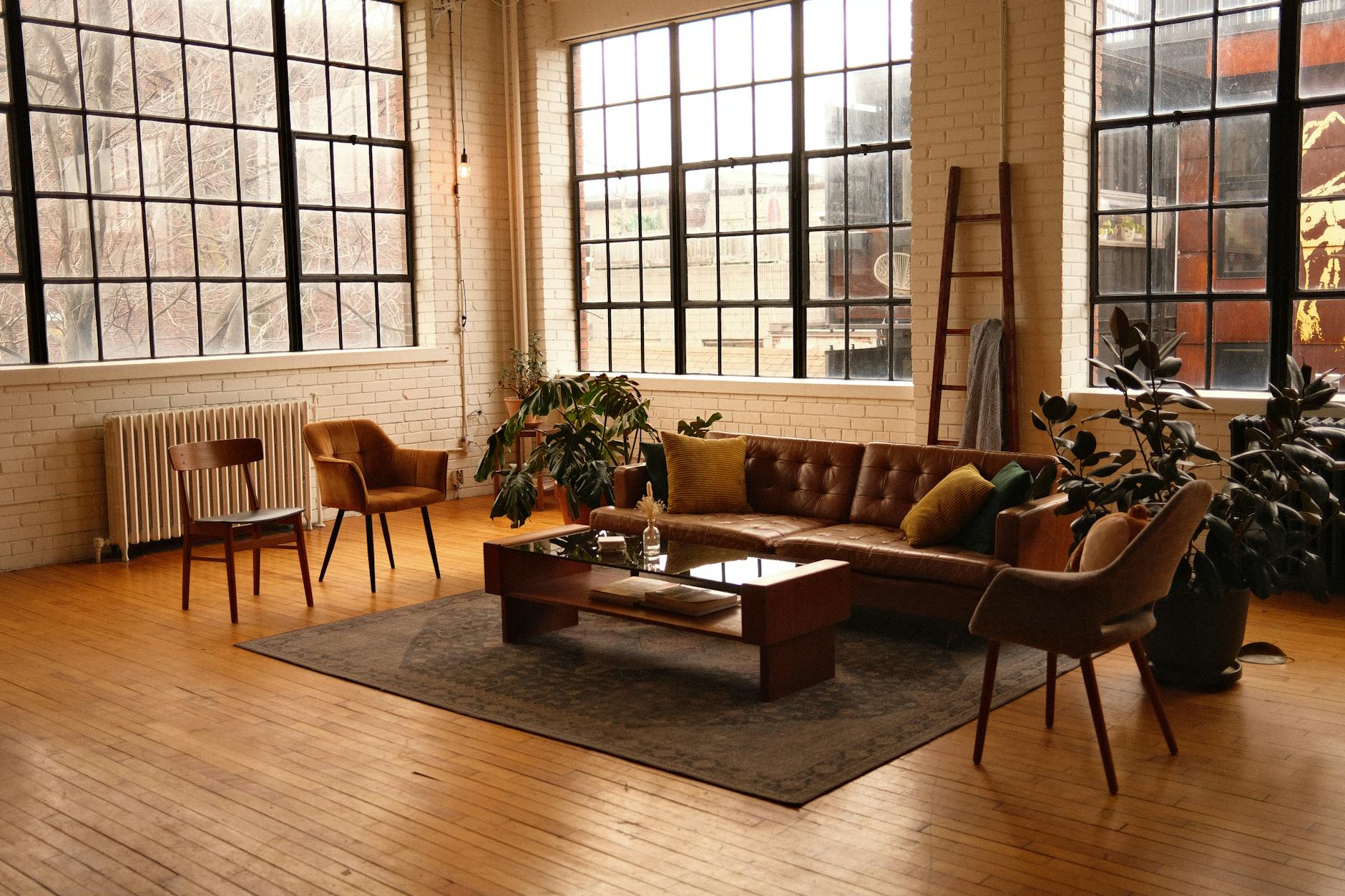 view of a loft style living room with a brown leather sofa