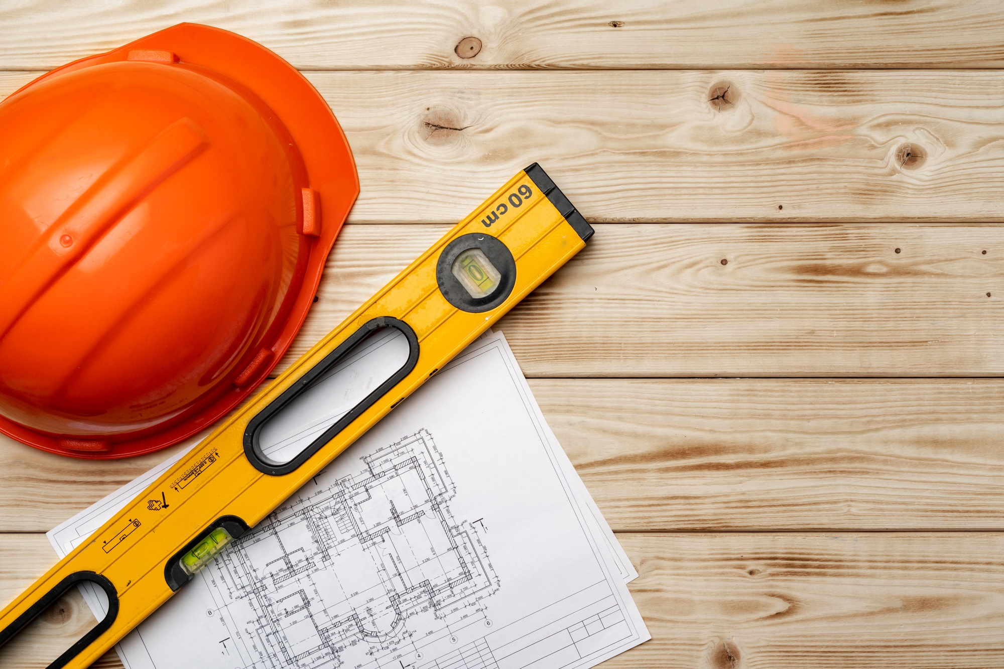 Construction worker hardhat, blueprints and .construction level, top view