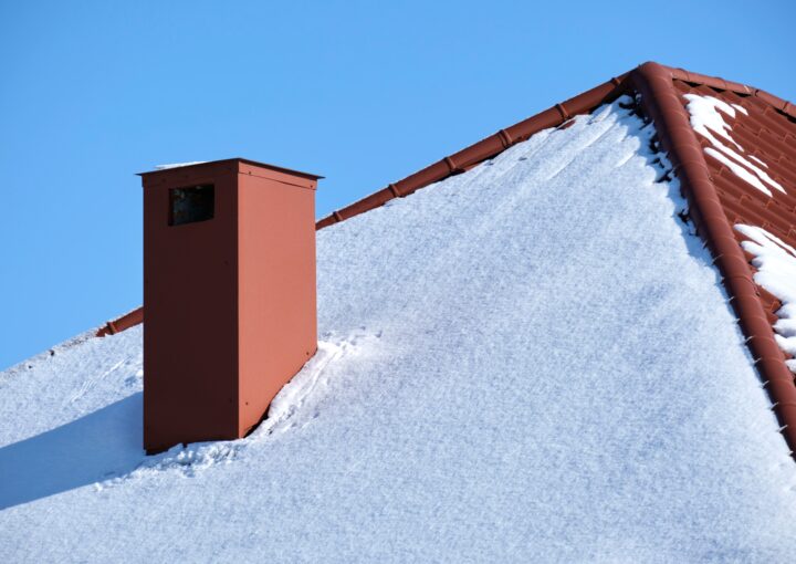 Closeup of house roof top covered with snow in cold winter.